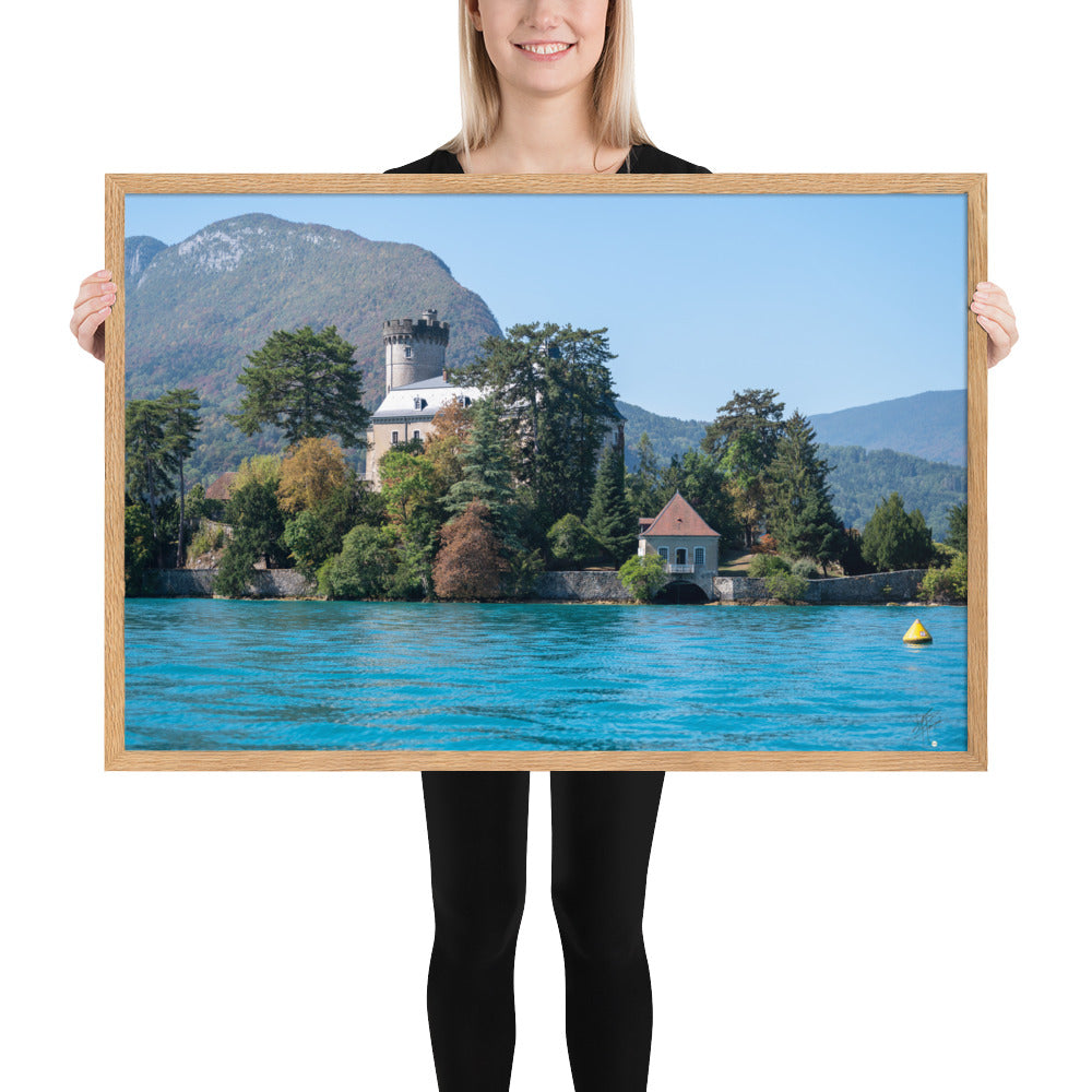 Vue panoramique du Château de Duingt, dominé par des montagnes, avec le Lac d'Annecy reflétant l'édifice, encadré en chêne.