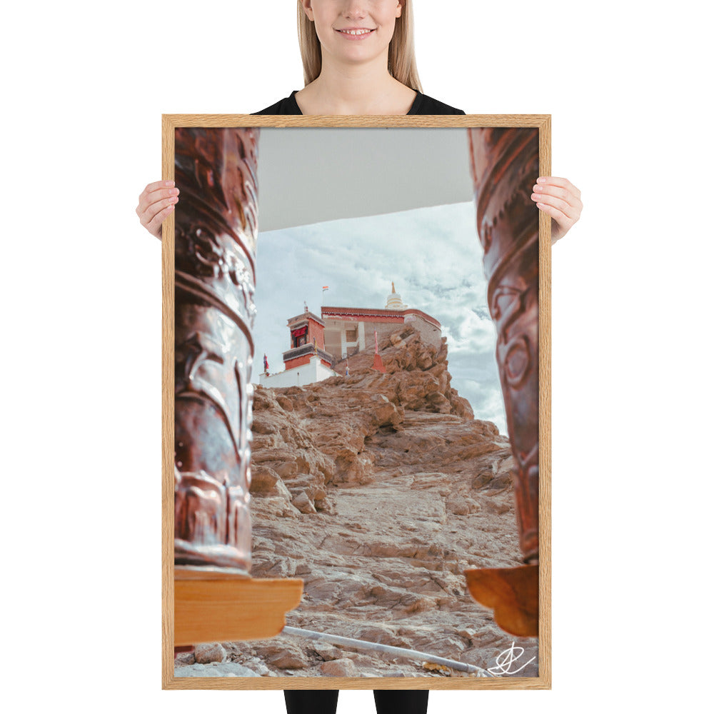 Photographie 'Le Temple sur la Montagne' par Ilan Shoham, montrant le monastère de Thiksey perché sur les hauteurs du Ladakh, encadré par des rouleaux à prières, avec un ciel azur en arrière-plan.