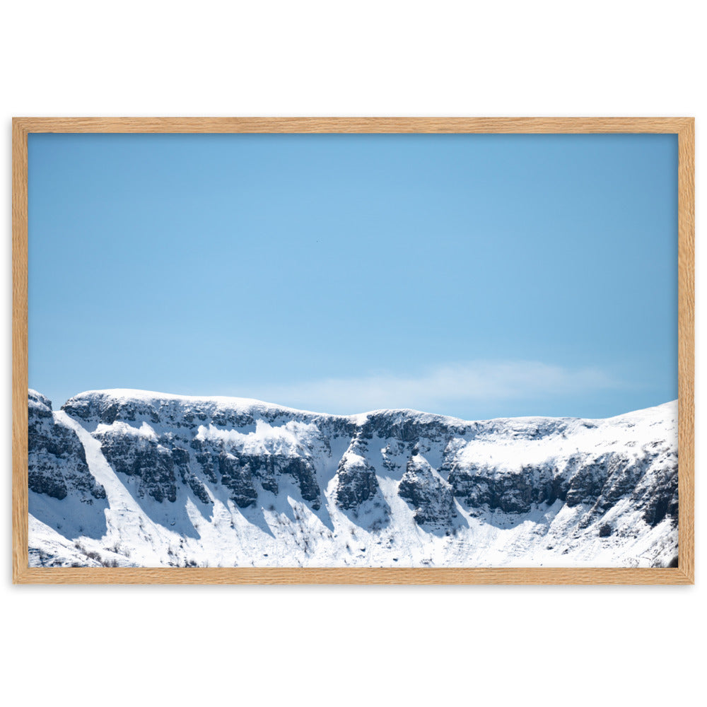 Photographie des montagnes enneigées du Cantal sous un ciel bleu ensoleillé