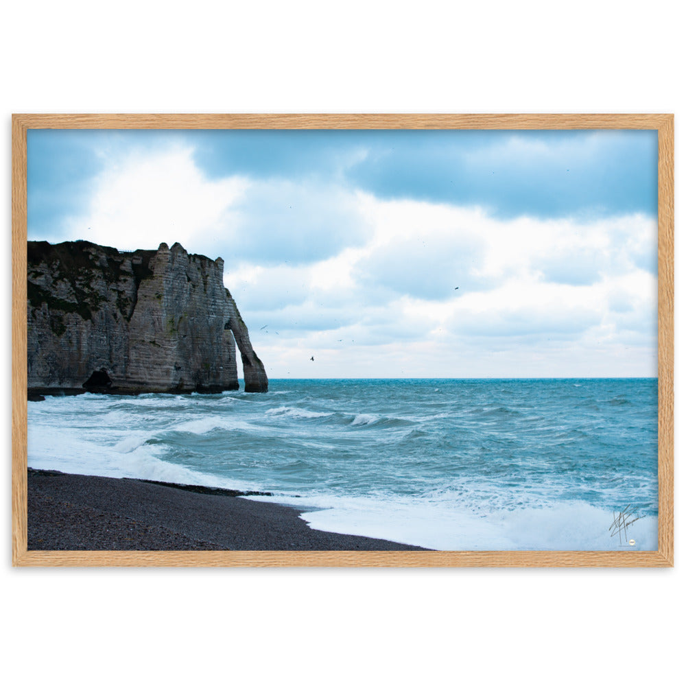 Photographie apaisante de la plage d'Etretat, où la mer caresse le rivage sous un ciel clair. Une représentation parfaite de la tranquillité et de la beauté naturelle de la côte normande.