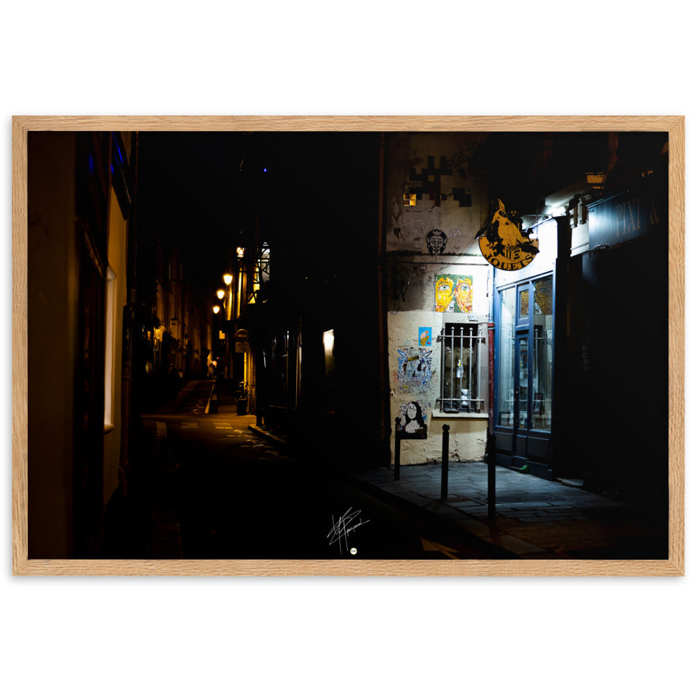 Photographie nocturne d'une rue parisienne, combinant éclats d'art urbain et lumière douce d'un magasin de jouets, évoquant la diversité et le charme artistique de la capitale.