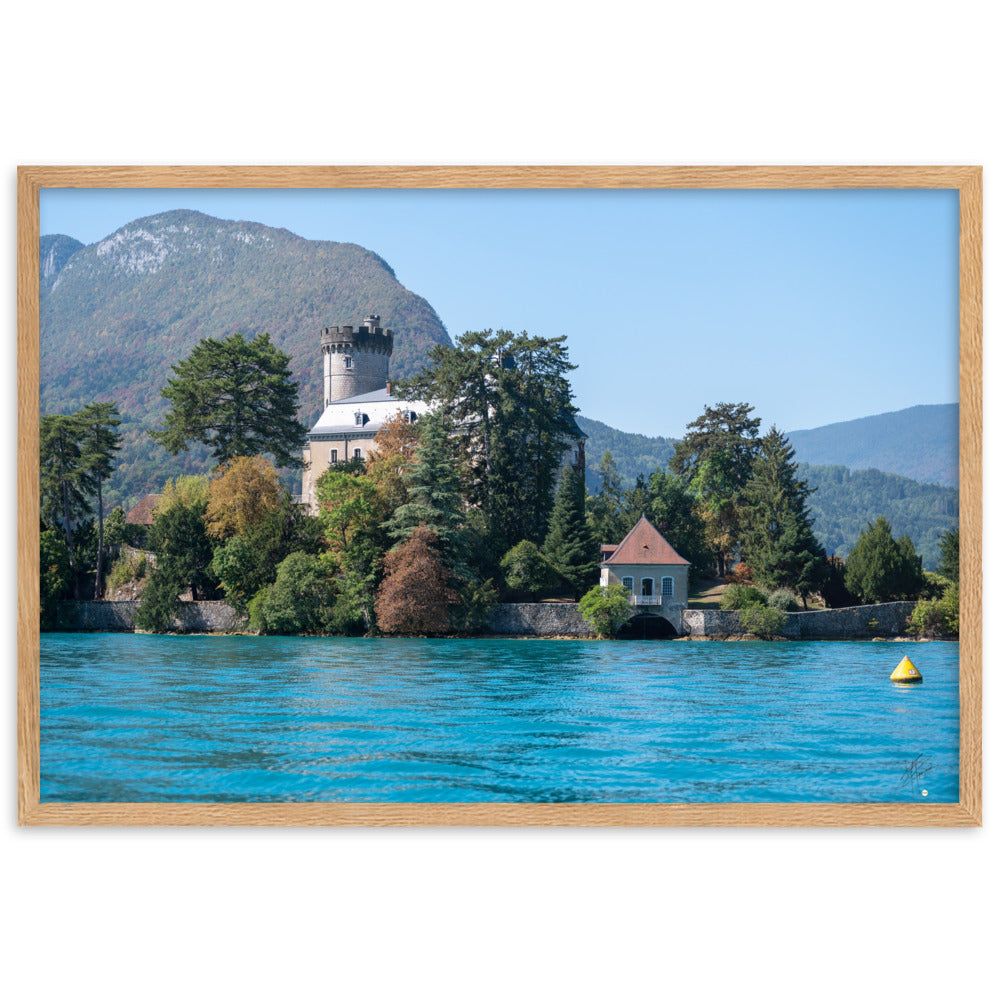 Vue panoramique du Château de Duingt, dominé par des montagnes, avec le Lac d'Annecy reflétant l'édifice, encadré en chêne.