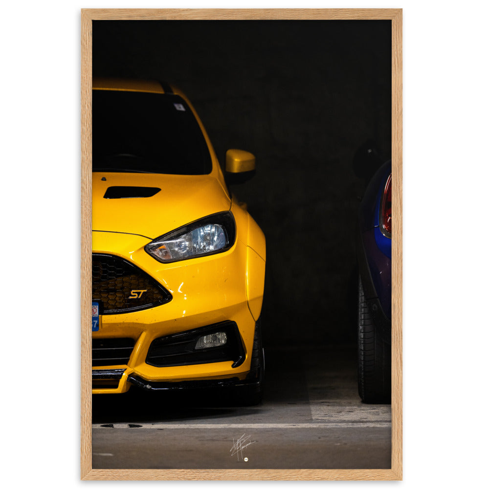 Ford Focus ST en teinte jaune brillante, éclairée dans un parking souterrain sombre, encadrée en bois de chêne.