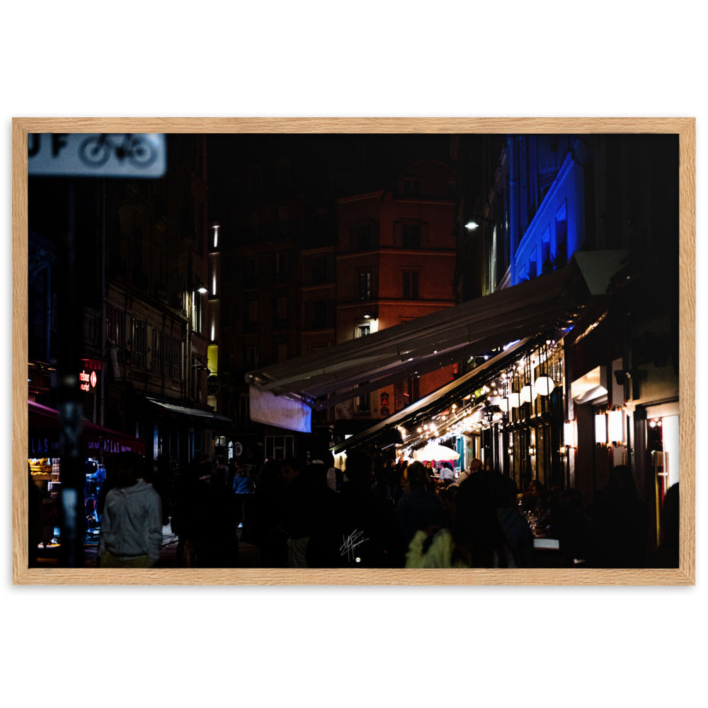 Rue animée de Paris la nuit, illuminée par des éclairages doux, encadrée d'un bois de chêne.