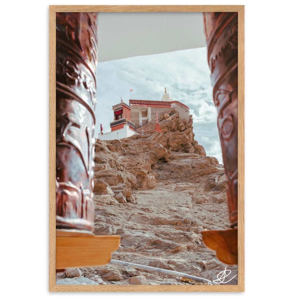 Photographie 'Le Temple sur la Montagne' par Ilan Shoham, montrant le monastère de Thiksey perché sur les hauteurs du Ladakh, encadré par des rouleaux à prières, avec un ciel azur en arrière-plan.