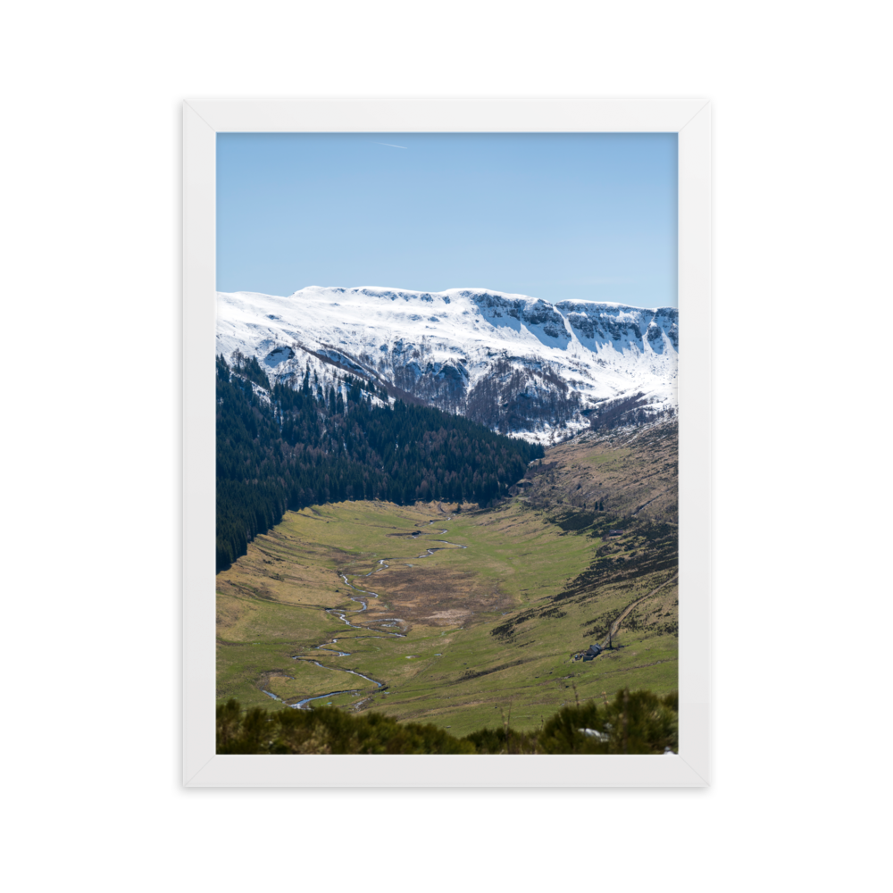 Poster d'une vallée verdoyante avec des montagnes enneigées en arrière-plan, situées dans le Cantal