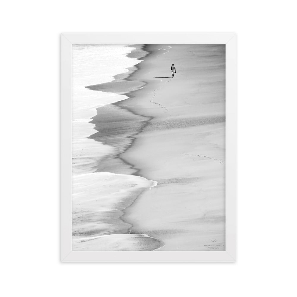 Poster encadré 'Le marcheur solitaire' en noir et blanc, capturant une silhouette solitaire sur une plage paisible, photographié par Veronique Botella.