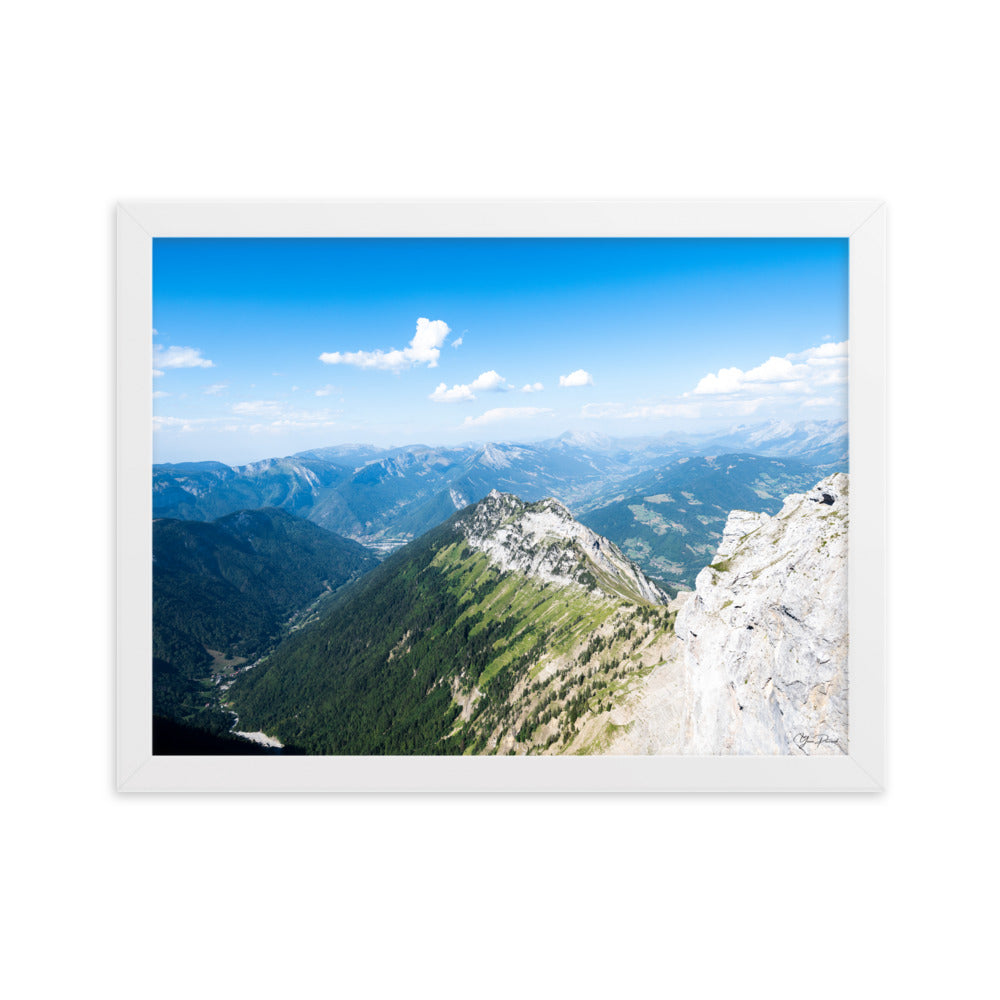 Photographie panoramique des Alpes avec montagnes robustes, vallées verdoyantes, nuages flottants et ciel bleu azur.