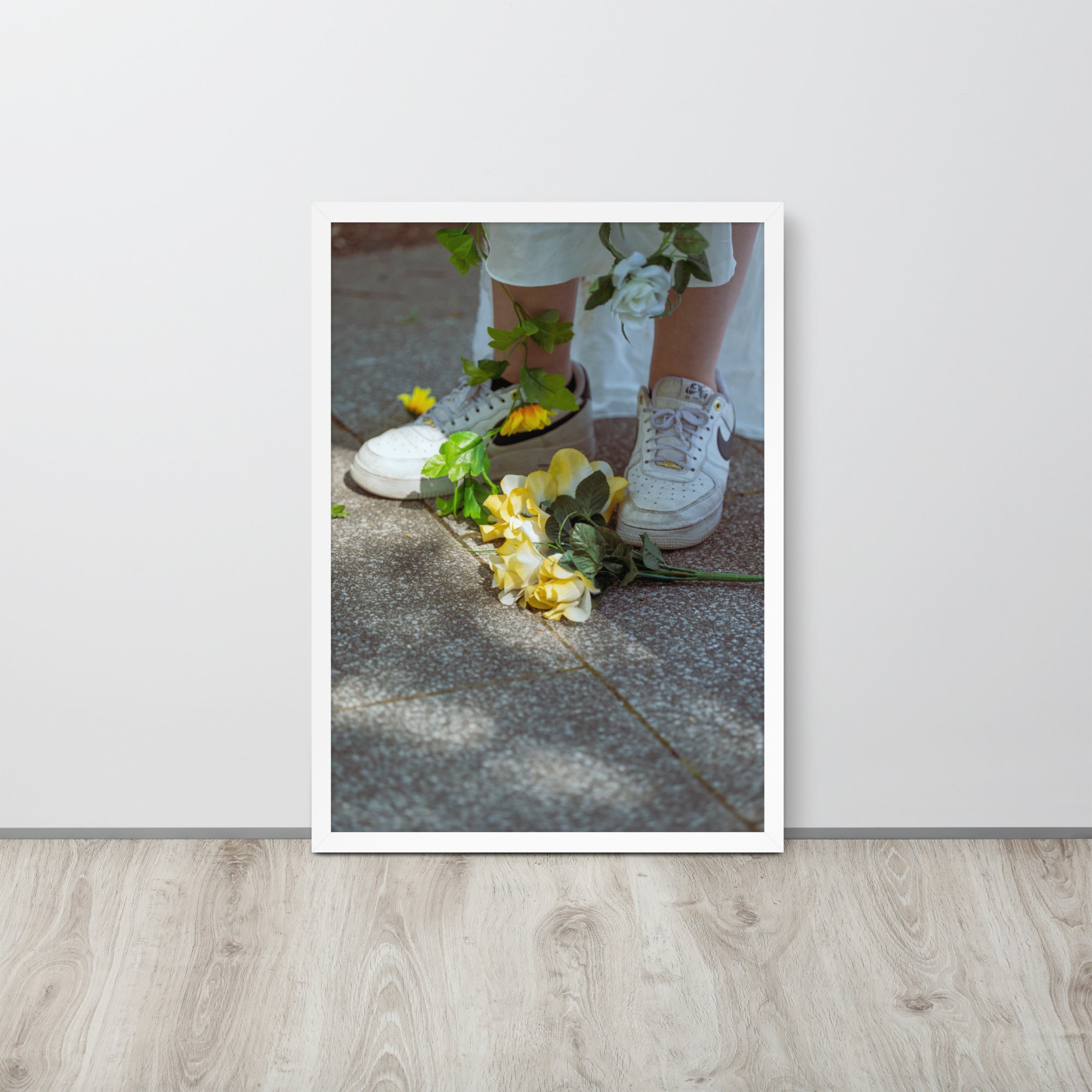 Poster encadré 'Flowers Nike' montrant des fleurs jaunes aux pieds d'une femme en blanc portant des Nike Air Force