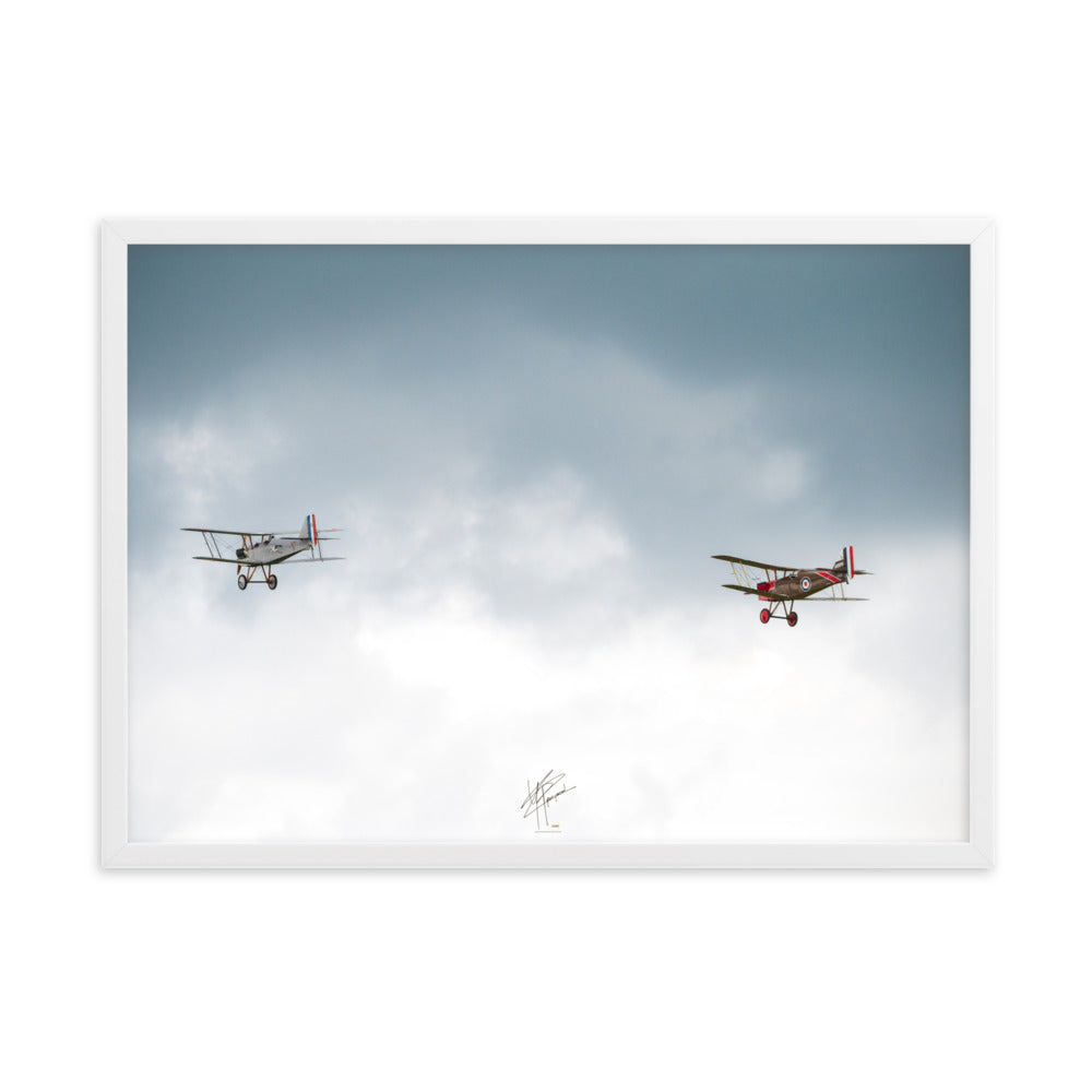 Deux avions de combat de la Première Guerre Mondiale s'élevant contre un ciel gris-blanc, encapsulant l'héroïsme de l'époque. Poster encadré de haute qualité signé 'Tagazou'.