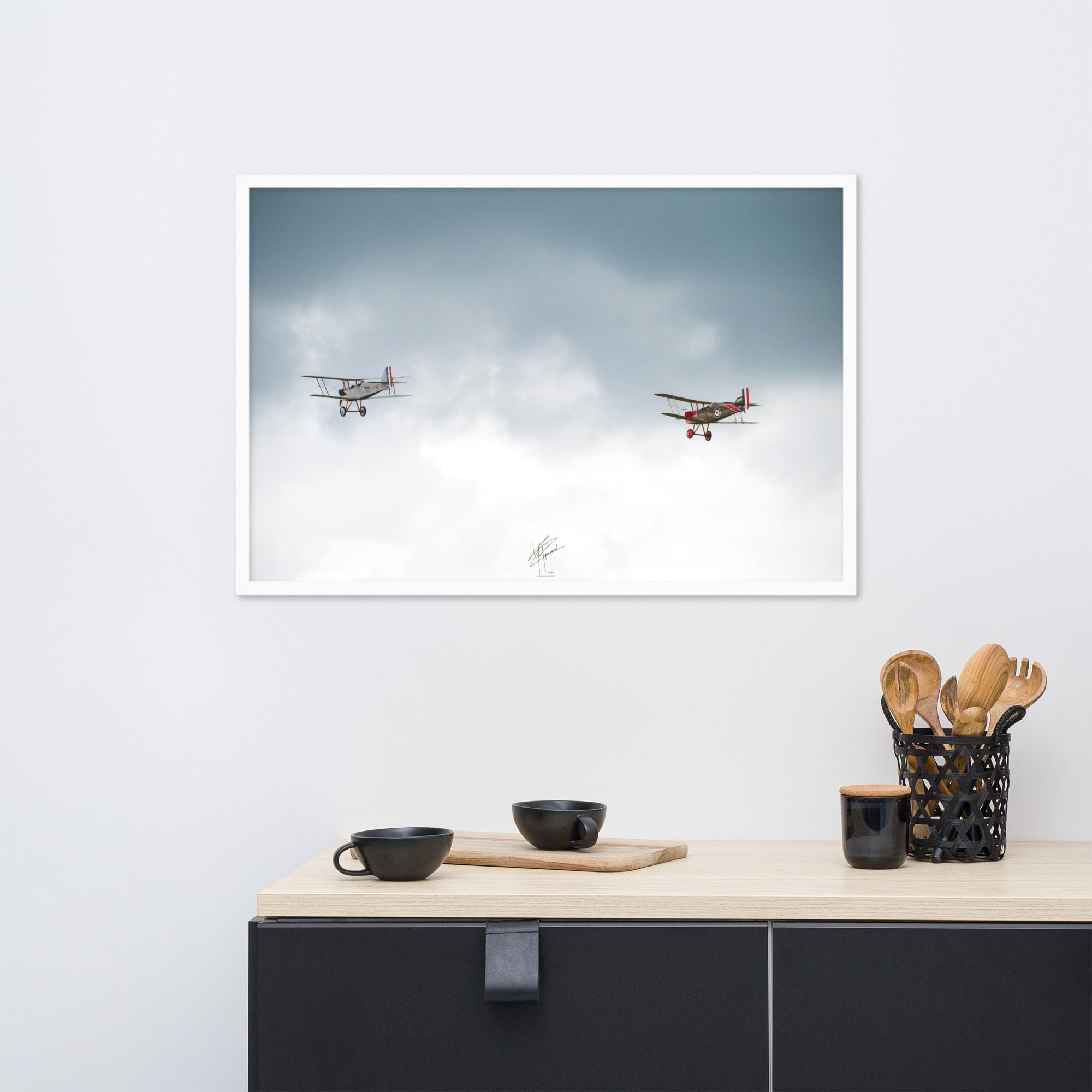 Deux avions de combat de la Première Guerre Mondiale s'élevant contre un ciel gris-blanc, encapsulant l'héroïsme de l'époque. Poster encadré de haute qualité signé 'Tagazou'.