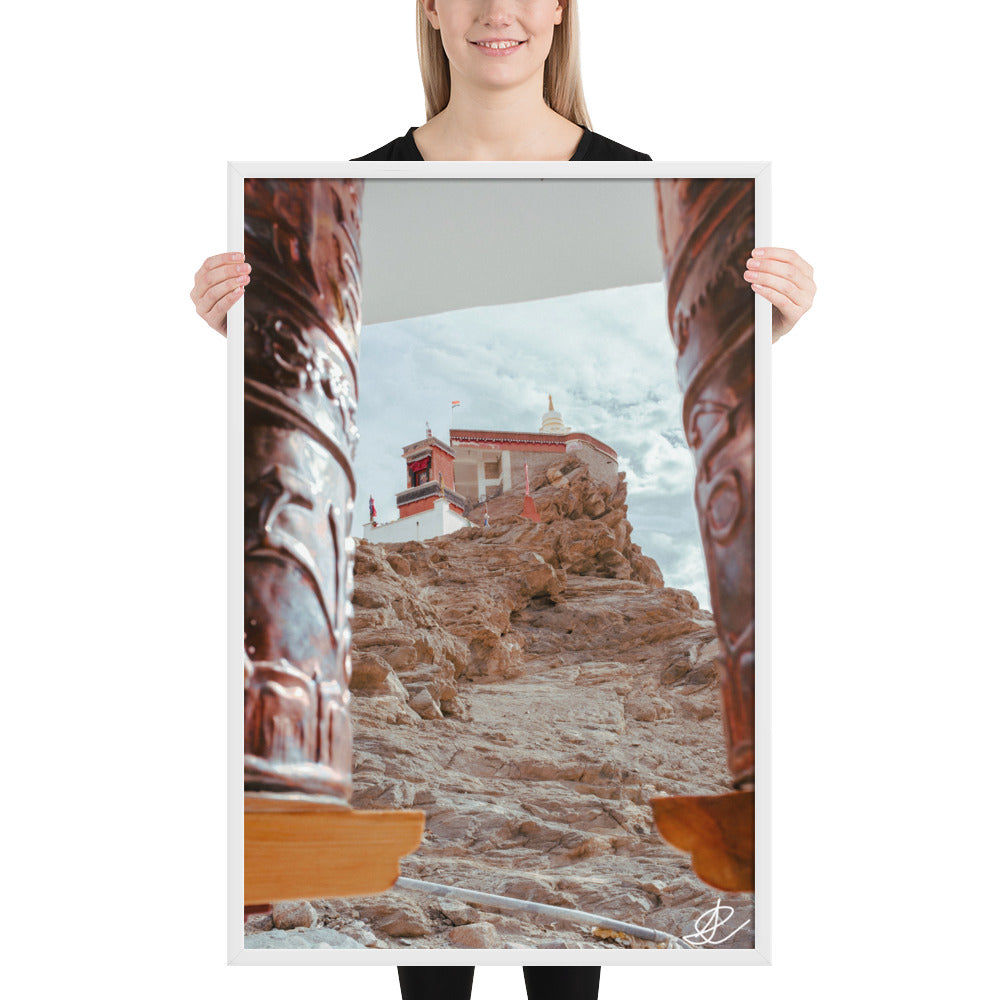 Photographie 'Le Temple sur la Montagne' par Ilan Shoham, montrant le monastère de Thiksey perché sur les hauteurs du Ladakh, encadré par des rouleaux à prières, avec un ciel azur en arrière-plan.