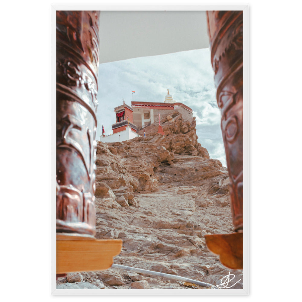 Photographie 'Le Temple sur la Montagne' par Ilan Shoham, montrant le monastère de Thiksey perché sur les hauteurs du Ladakh, encadré par des rouleaux à prières, avec un ciel azur en arrière-plan.