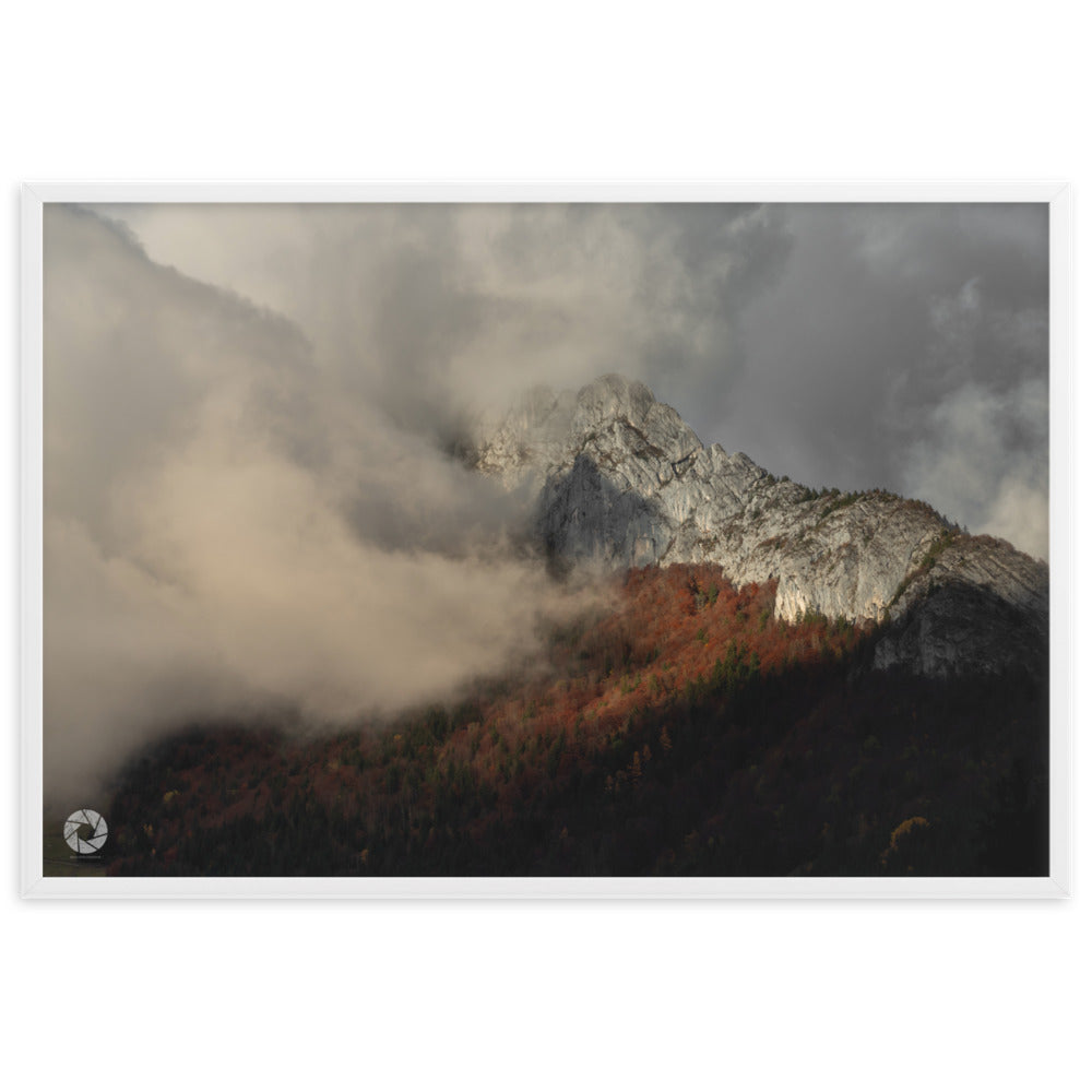 Photographie des montagnes émergeant au-dessus des nuages au coucher du soleil, capturée par Brad Explographie, offrant un panorama naturel majestueux et mystérieux.