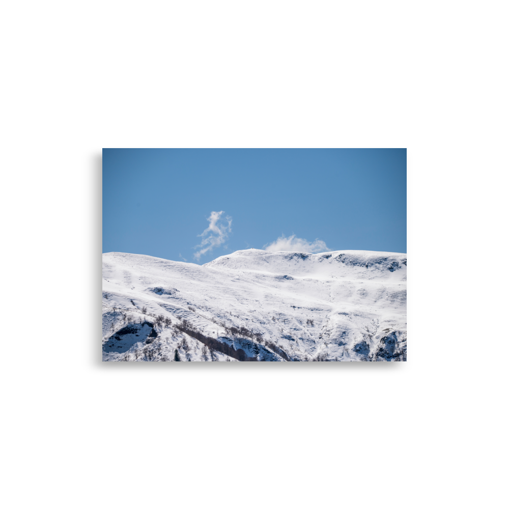 Photographie des montagnes enneigées du Cantal avec un nuage en forme de petit monstre.