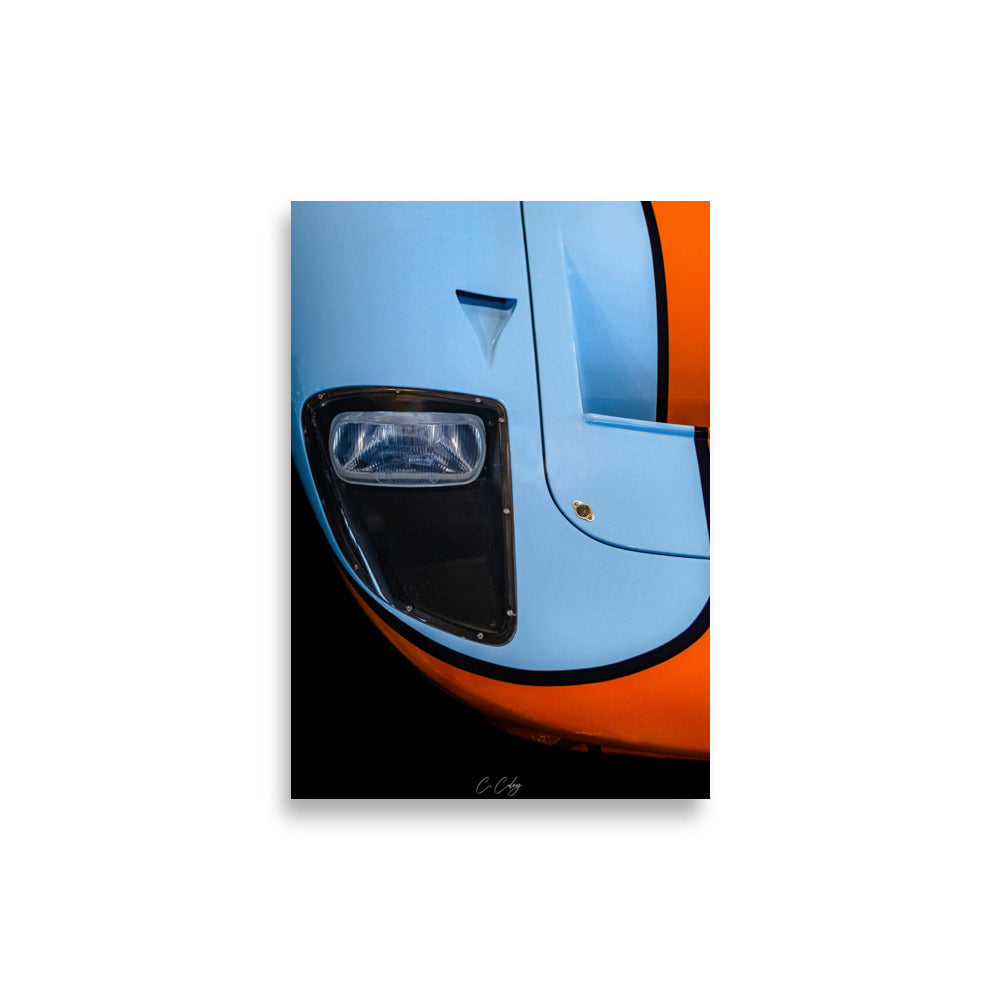 Poster 'GT40 Gulf' capturant la nostalgie de la Ford GT40 à travers un détail du bloc optique vintage et du capot bleu et orange, offrant une plongée visuelle dans l'histoire légendaire des courses automobiles par le photographe Charles Coley.