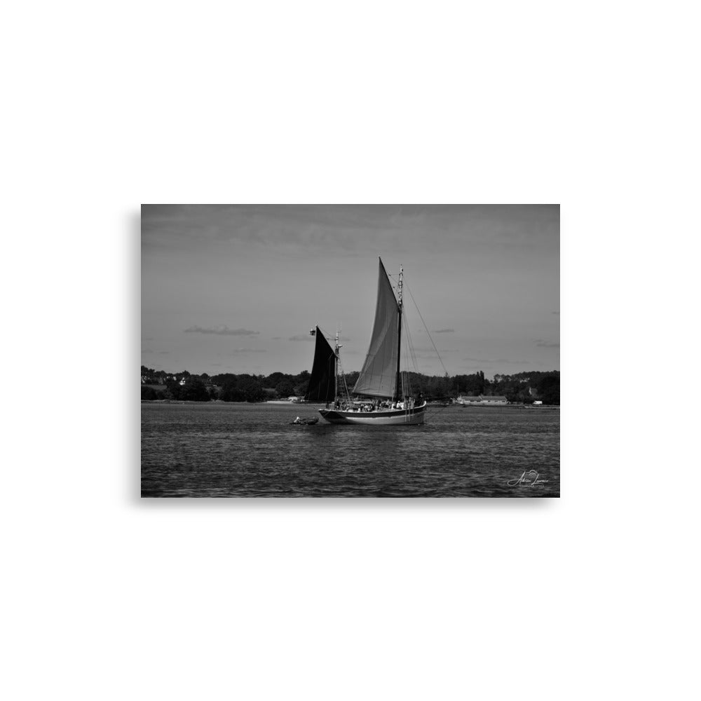 Photographie noir et blanc 'Hissez haut !' par Adrien Louraco, représentant un voilier naviguant sur le Golfe du Morbihan, avec des contrastes saisissants entre mer et ciel.