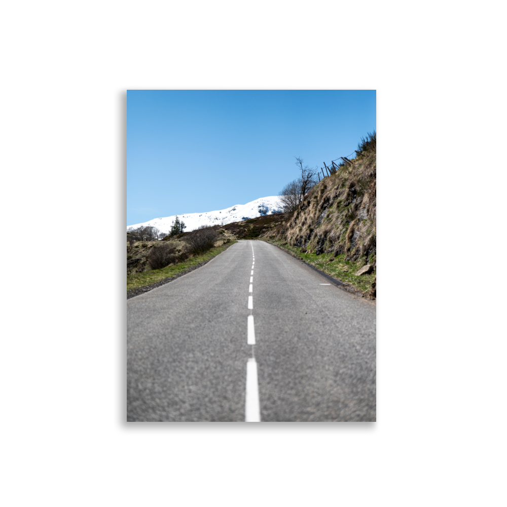 Photographie de route rurale menant à une montagne enneigée sous un ciel bleu dans le Cantal - Poster de paysage du Cantal