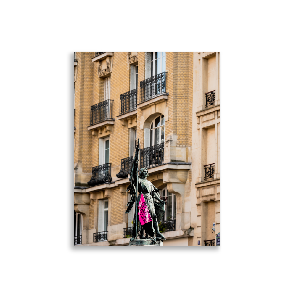 Poster de photographie d'une statue de Jeanne d'Arc ornée d'un drapeau rose de protestation.