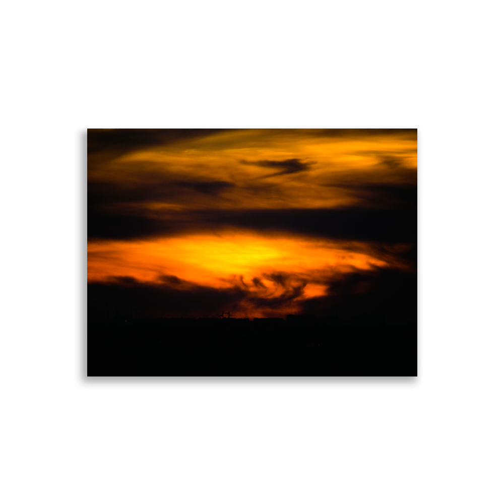 Coucher de soleil mêlé à des nuages très sombres, créant une impression de tempête dans le ciel.