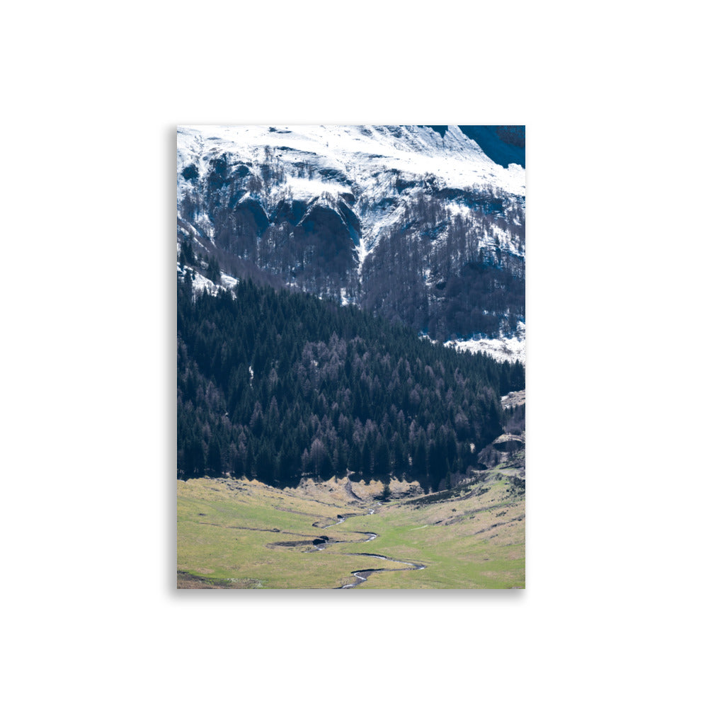 Photographie du paysage majestueux du Puy Mary en Auvergne, montrant des sommets enneigés et une vallée verdoyante.