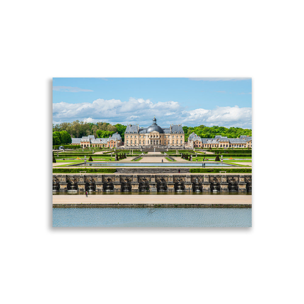 Photographie du Château de Vaux-le-Vicomte sous un ciel clair, mettant en valeur ses jardins impeccables et sa majestueuse architecture du XVIIe siècle.