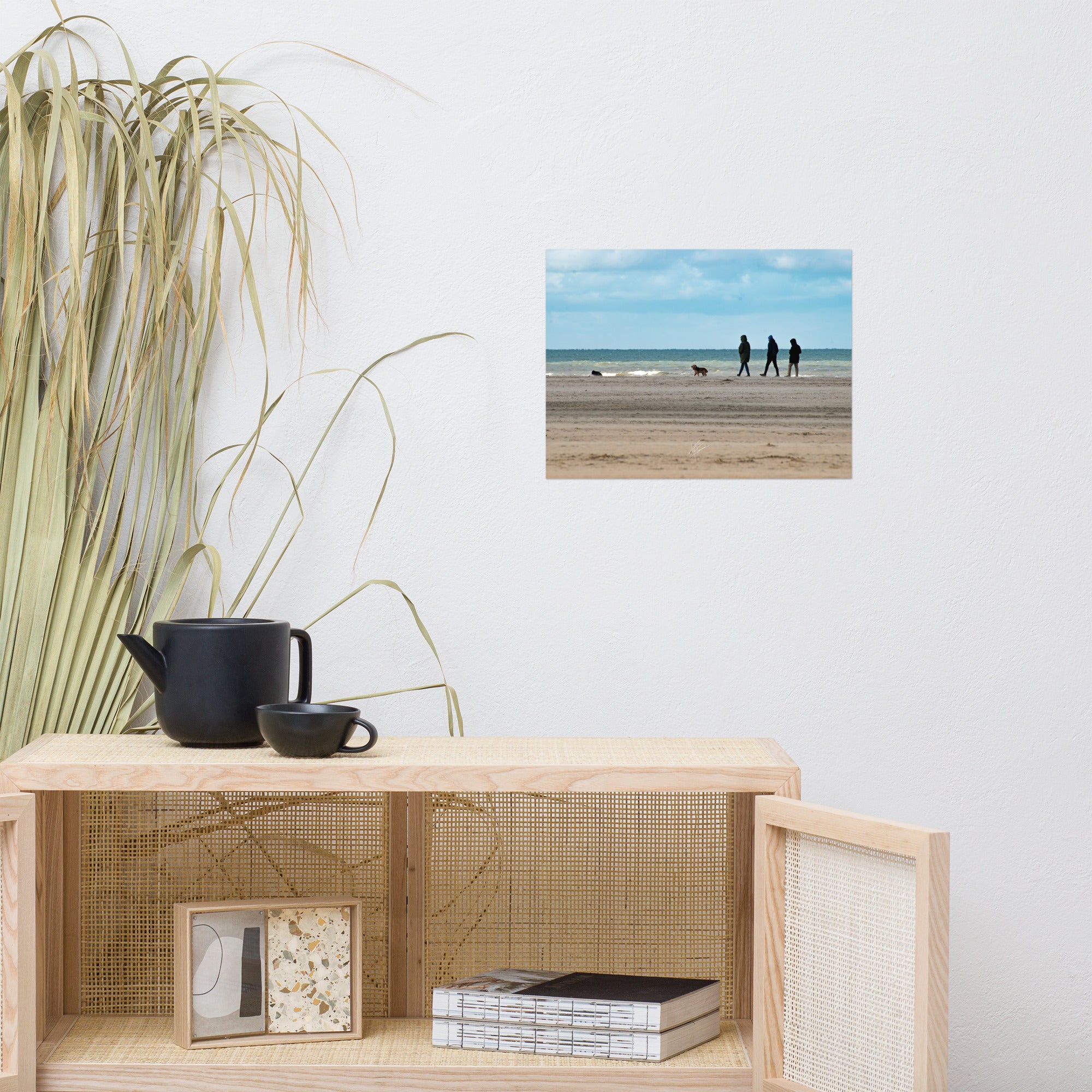 Photographie de la plage de Deauville avec des promeneurs et leur chien, capturant l'atmosphère tranquille et l'immensité de la mer normande.