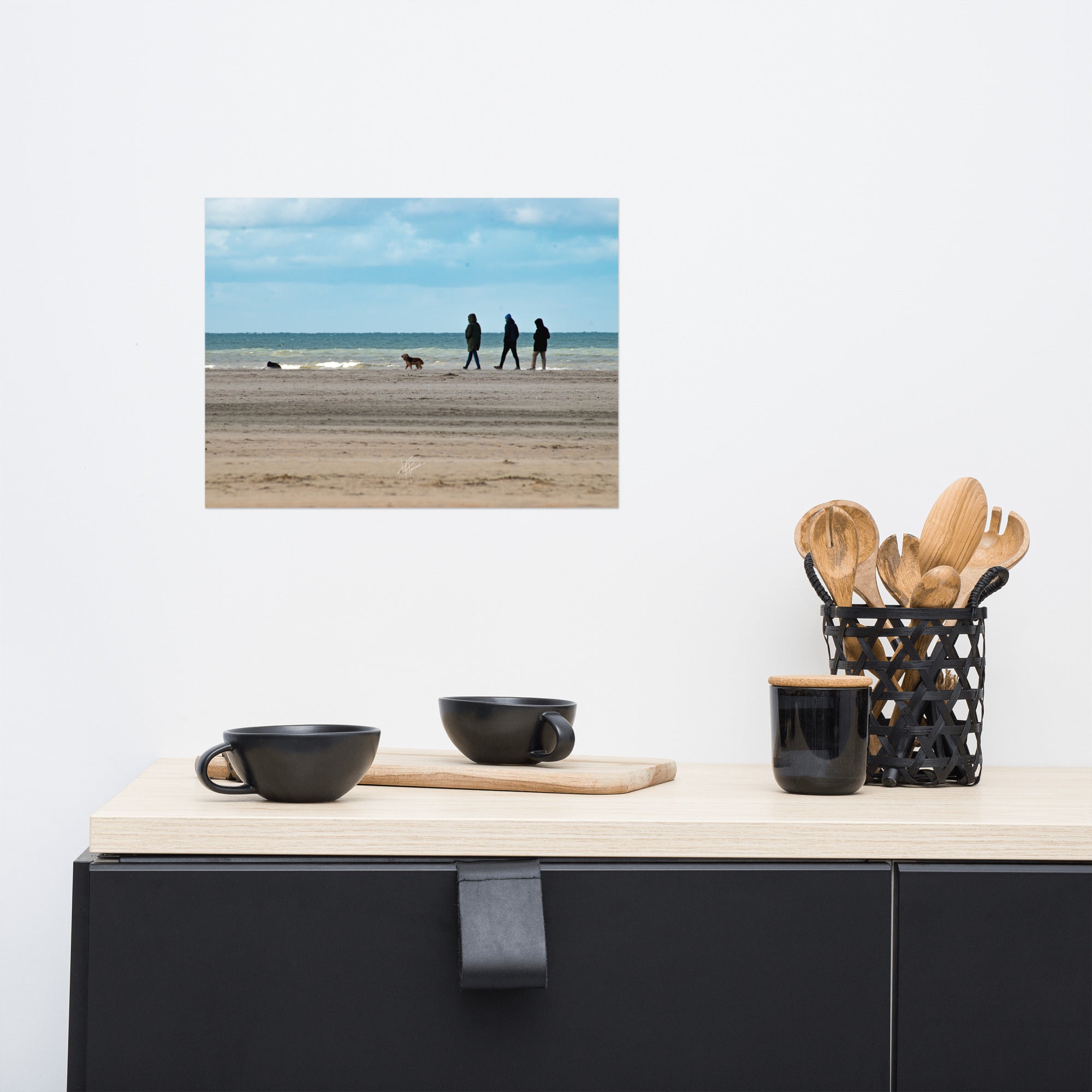 Photographie de la plage de Deauville avec des promeneurs et leur chien, capturant l'atmosphère tranquille et l'immensité de la mer normande.