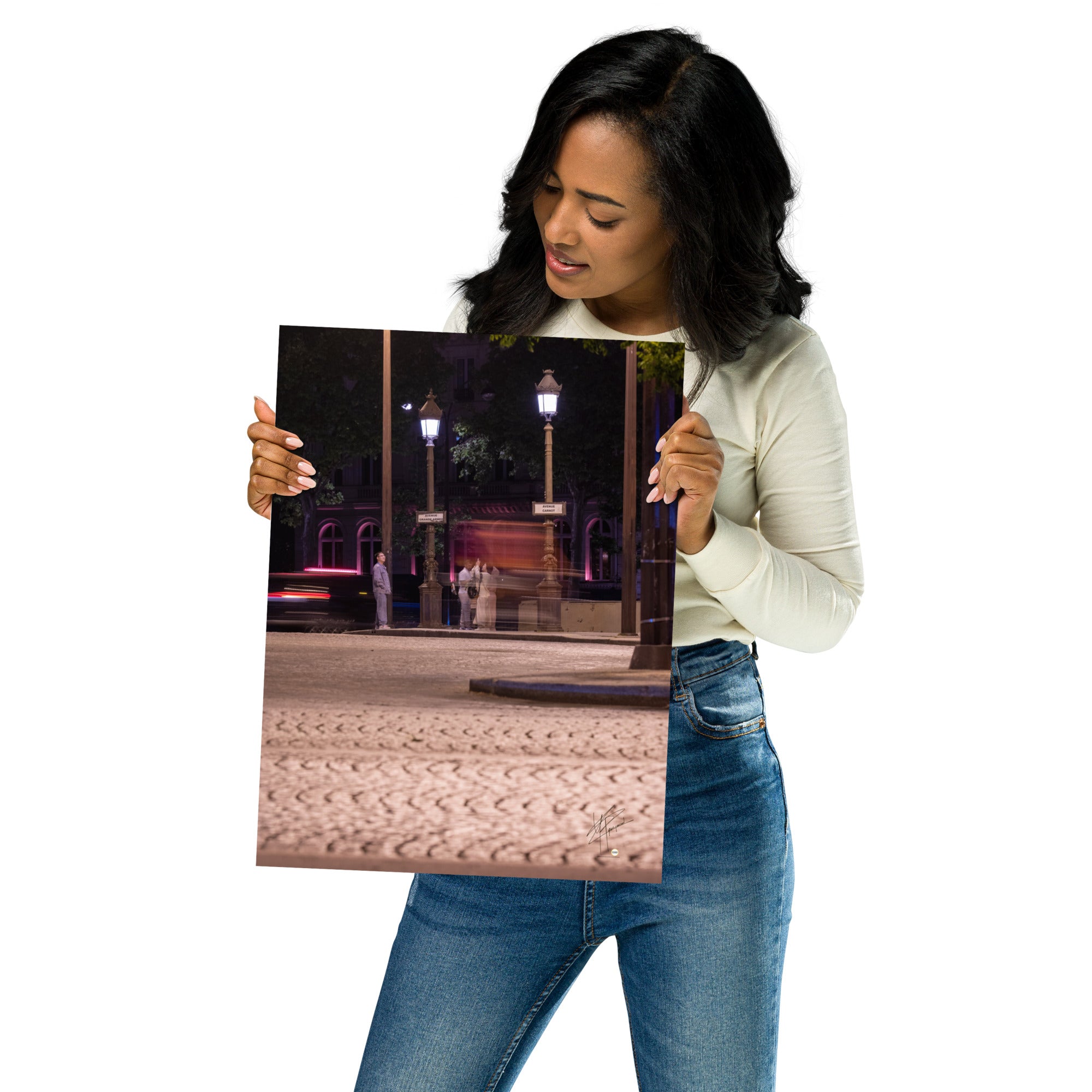 Photographie nocturne de l'Avenue de la Grande Armée à Paris, montrant quatre touristes prenant une photo, avec un arrière-plan de voitures en mouvement grâce à une longue exposition.