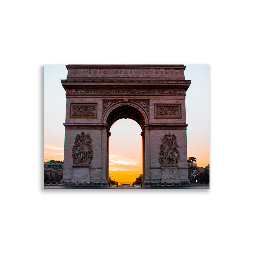 L'Arc de Triomphe de Paris au lever du soleil, ses contours majestueux se découpant contre un ciel orangé, symbolisant la gloire et l'espoir d'une nouvelle journée.