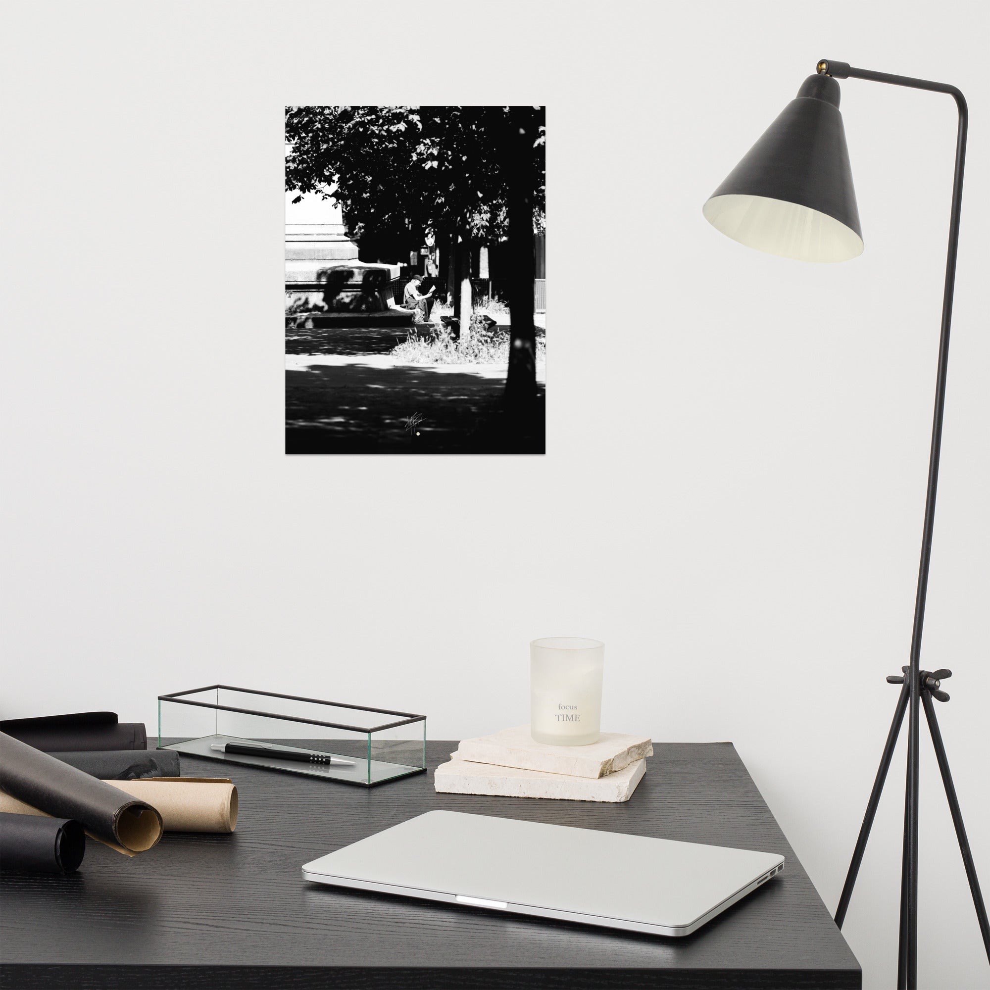 Poster photographique 'L'heure de lire', capturant un homme lisant un livre à Paris, en noir et blanc.