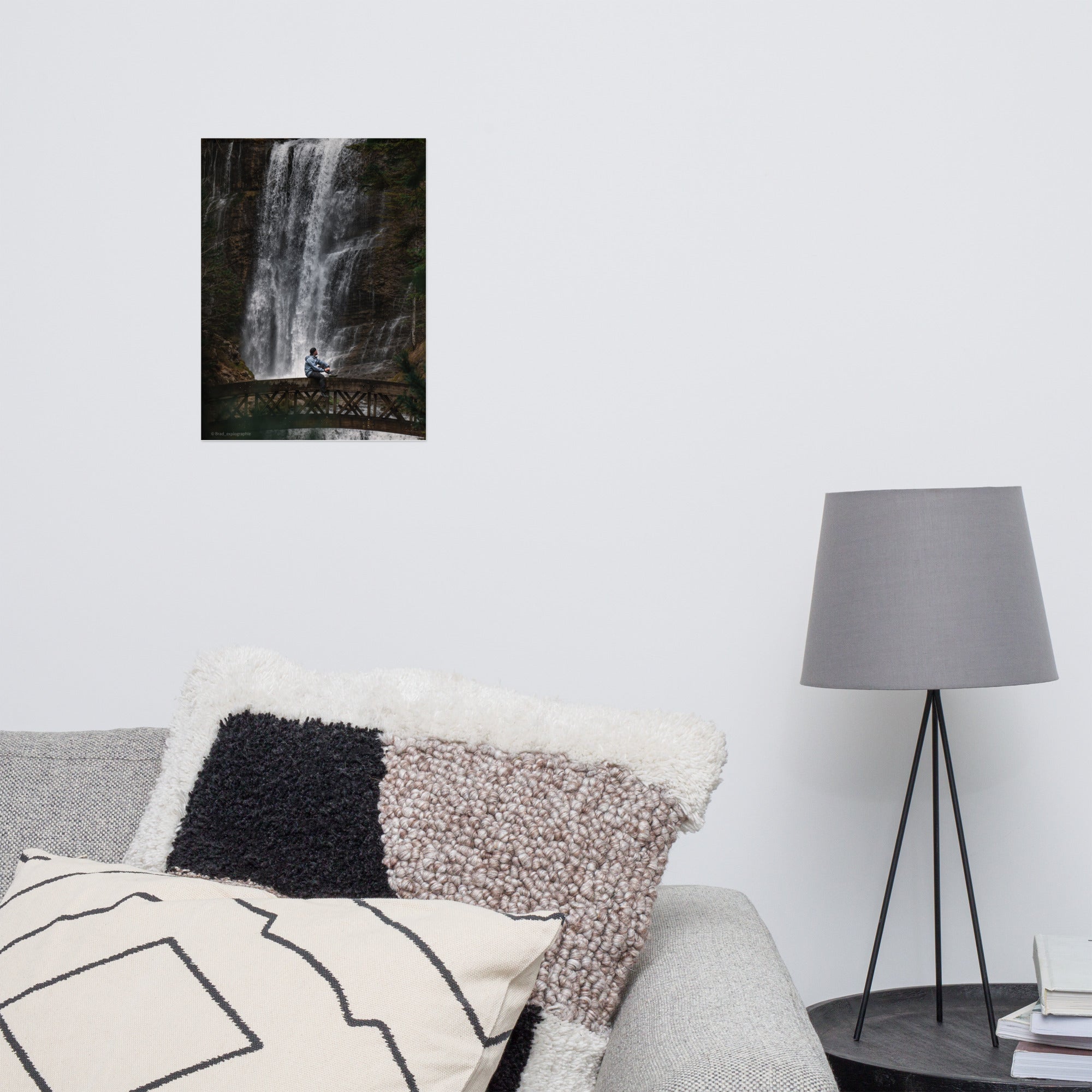 Homme méditatif assis sur une structure en bois au-dessus d'une rivière tumultueuse avec une cascade puissante en arrière-plan – photographie signée par Brad_explographie.