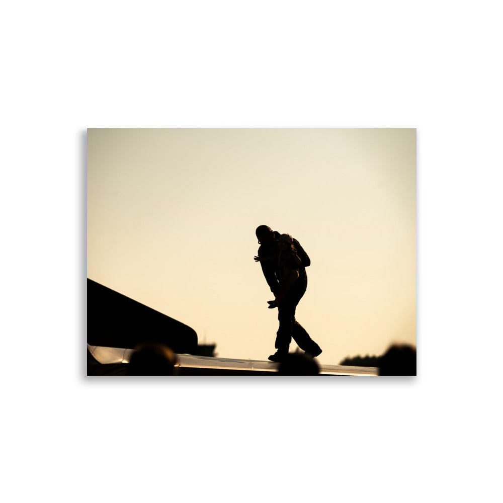 Photographie 'Héroïque' montrant un pilote et une fillette partageant un moment émouvant sur l'aile d'un avion, sous une lumière jaune orangée, capturé par l'artiste Yann Peccard.