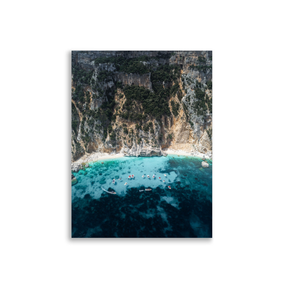 Poster d'une plage avec de l'eau bleu clair au pied d'une falaise