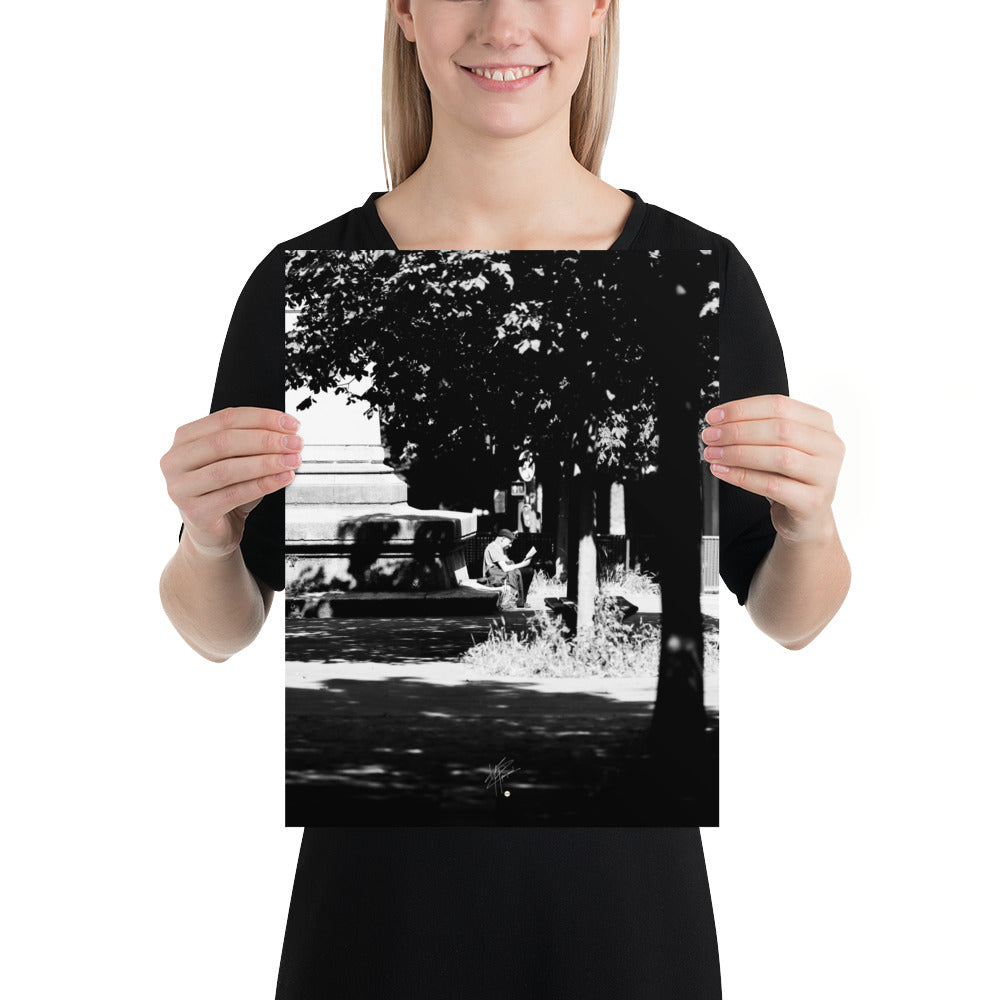 Poster photographique 'L'heure de lire', capturant un homme lisant un livre à Paris, en noir et blanc.