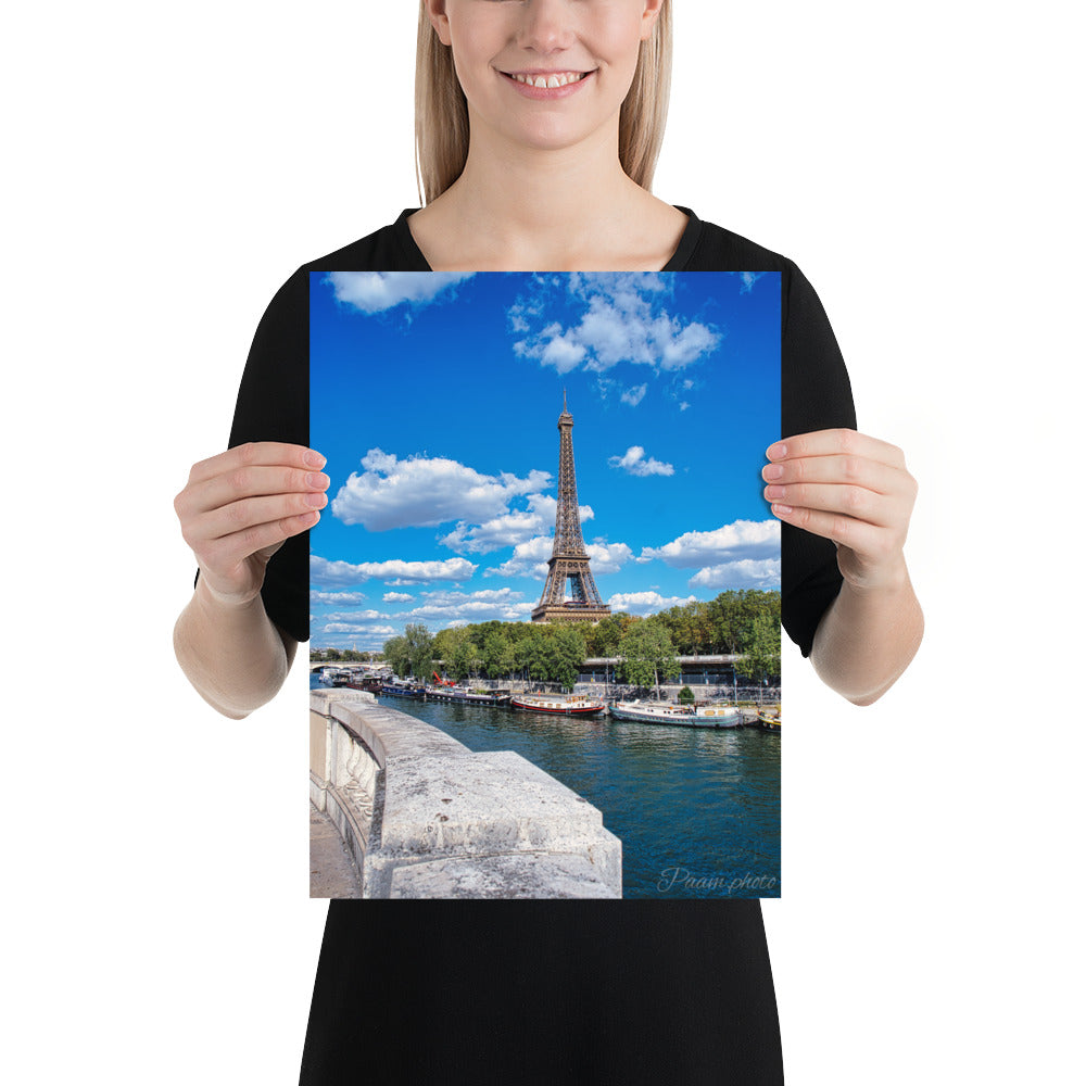 Vue panoramique de la Tour Eiffel et des péniches sur la Seine, sous un ciel bleu nuageux – une œuvre signée Antony Porlier.