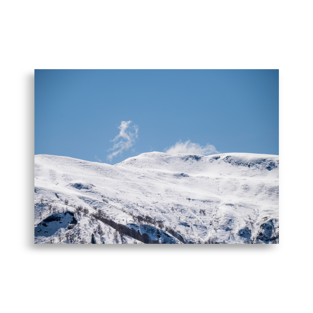 Photographie des montagnes enneigées du Cantal avec un nuage en forme de petit monstre.