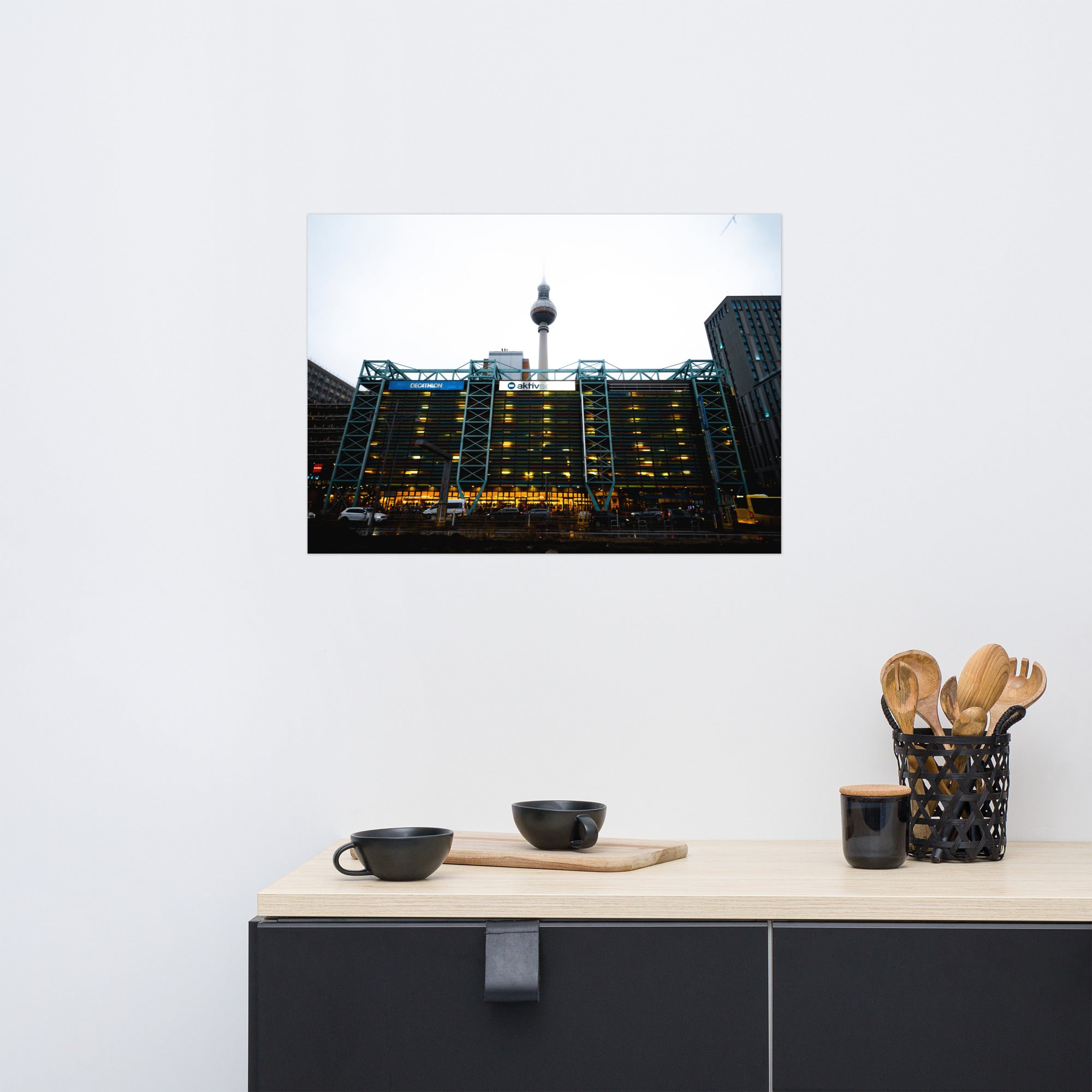 Photographie du parking moderne multi-étages "Parkhaus Rathauspassagen" à Berlin, illuminé avec la tour de télévision en arrière-plan.