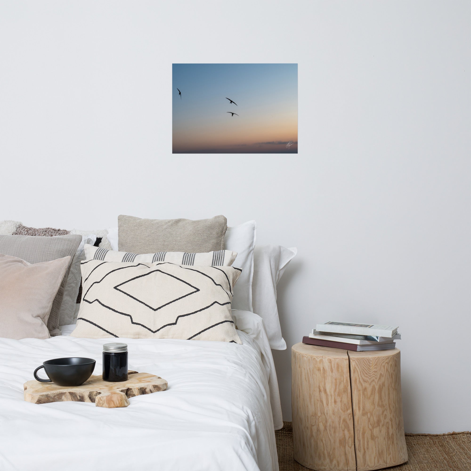 Trois oiseaux volant dans un ciel aux teintes de bleu, orange et jaune.