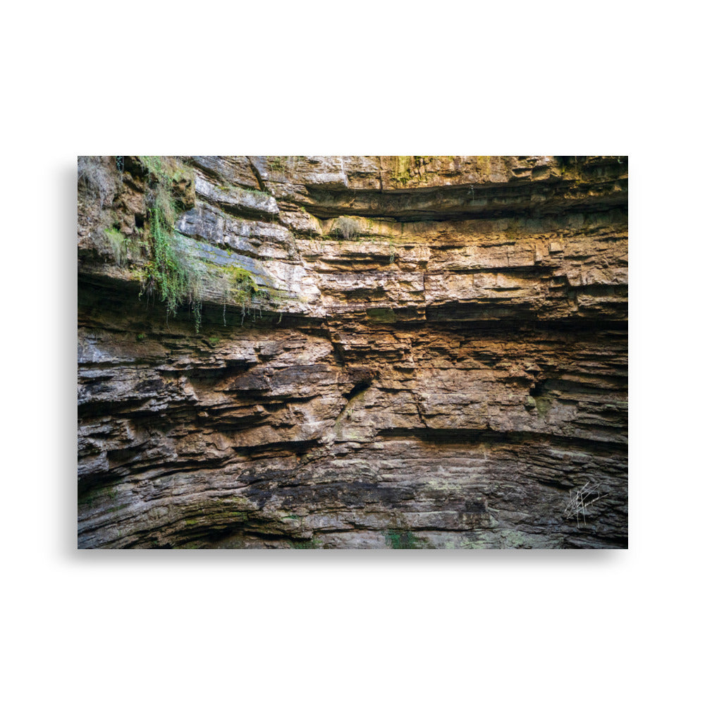 Photographie détaillée d'un mur de roche souterrain au gouffre de Padirac montrant des couches distinctes et des signes d'érosion.