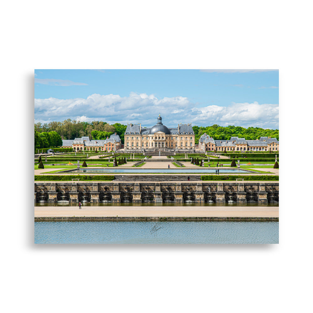 Photographie du Château de Vaux-le-Vicomte sous un ciel clair, mettant en valeur ses jardins impeccables et sa majestueuse architecture du XVIIe siècle.