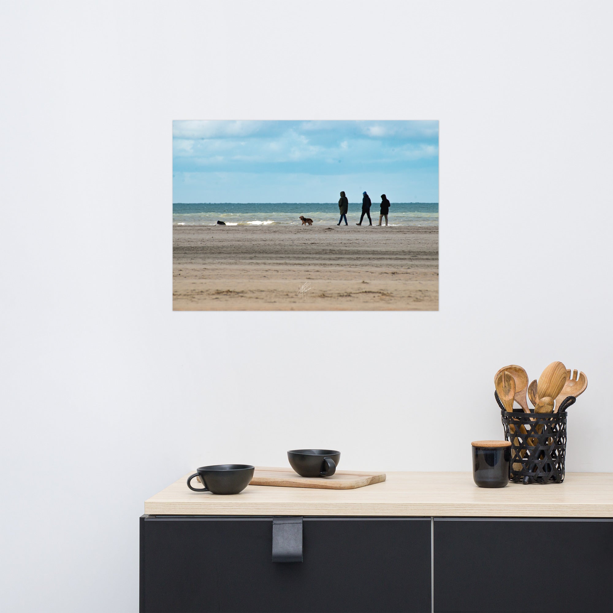 Photographie de la plage de Deauville avec des promeneurs et leur chien, capturant l'atmosphère tranquille et l'immensité de la mer normande.