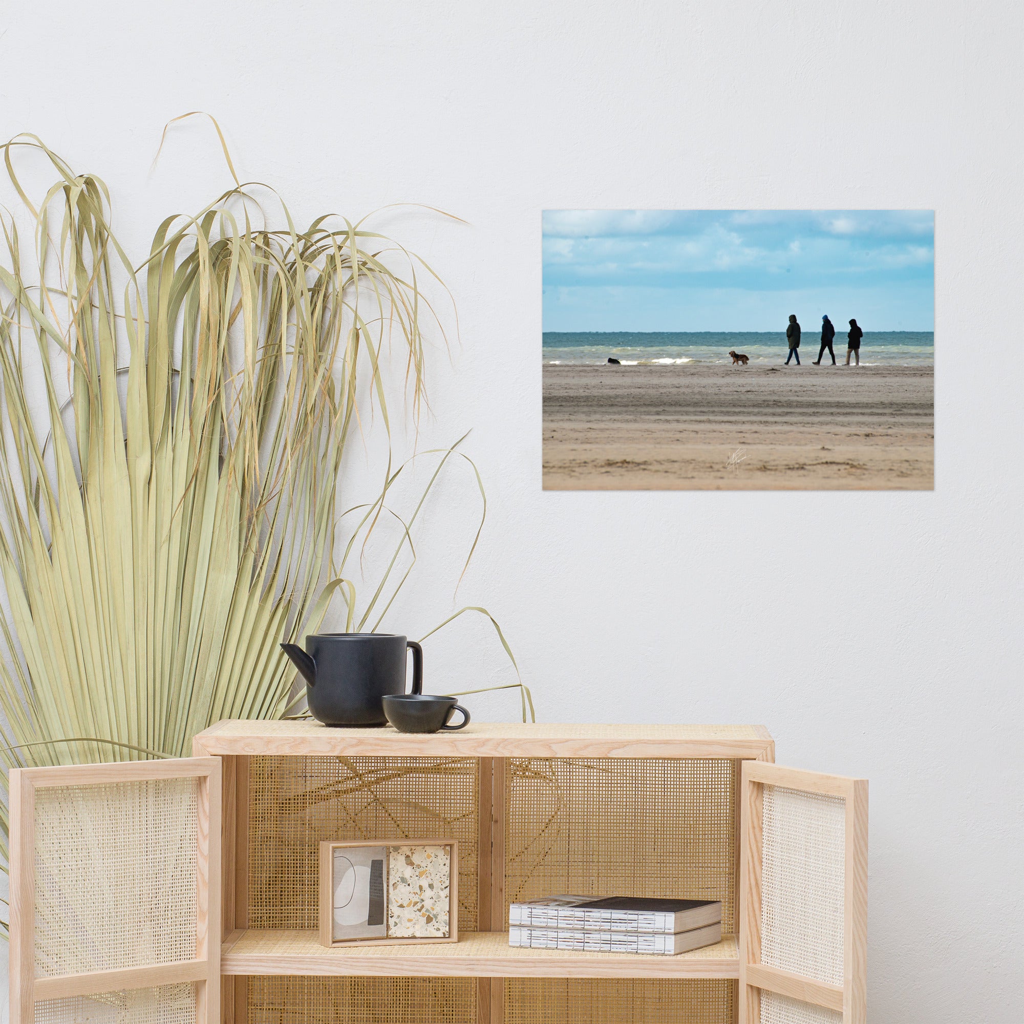 Photographie de la plage de Deauville avec des promeneurs et leur chien, capturant l'atmosphère tranquille et l'immensité de la mer normande.