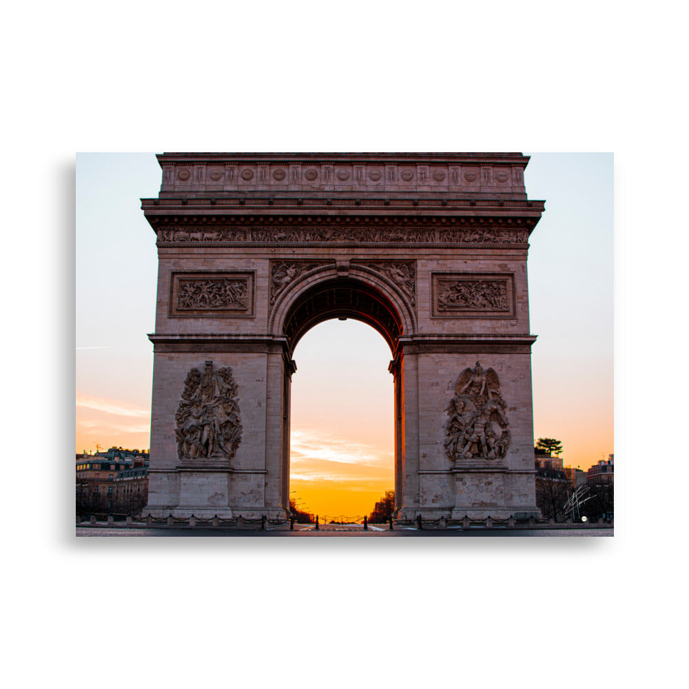 L'Arc de Triomphe de Paris au lever du soleil, ses contours majestueux se découpant contre un ciel orangé, symbolisant la gloire et l'espoir d'une nouvelle journée.