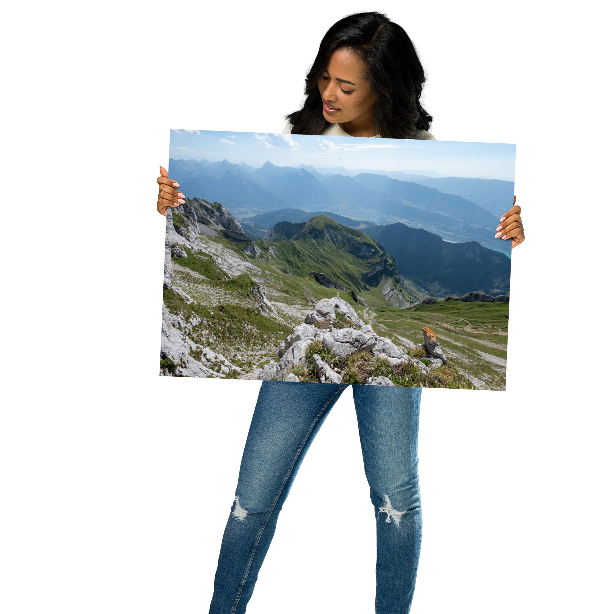 Vue panoramique du lac Annecy depuis les hauteurs, entouré de montagnes majestueuses avec un ciel serein au-dessus. Une représentation fidèle de la beauté naturelle des Alpes.