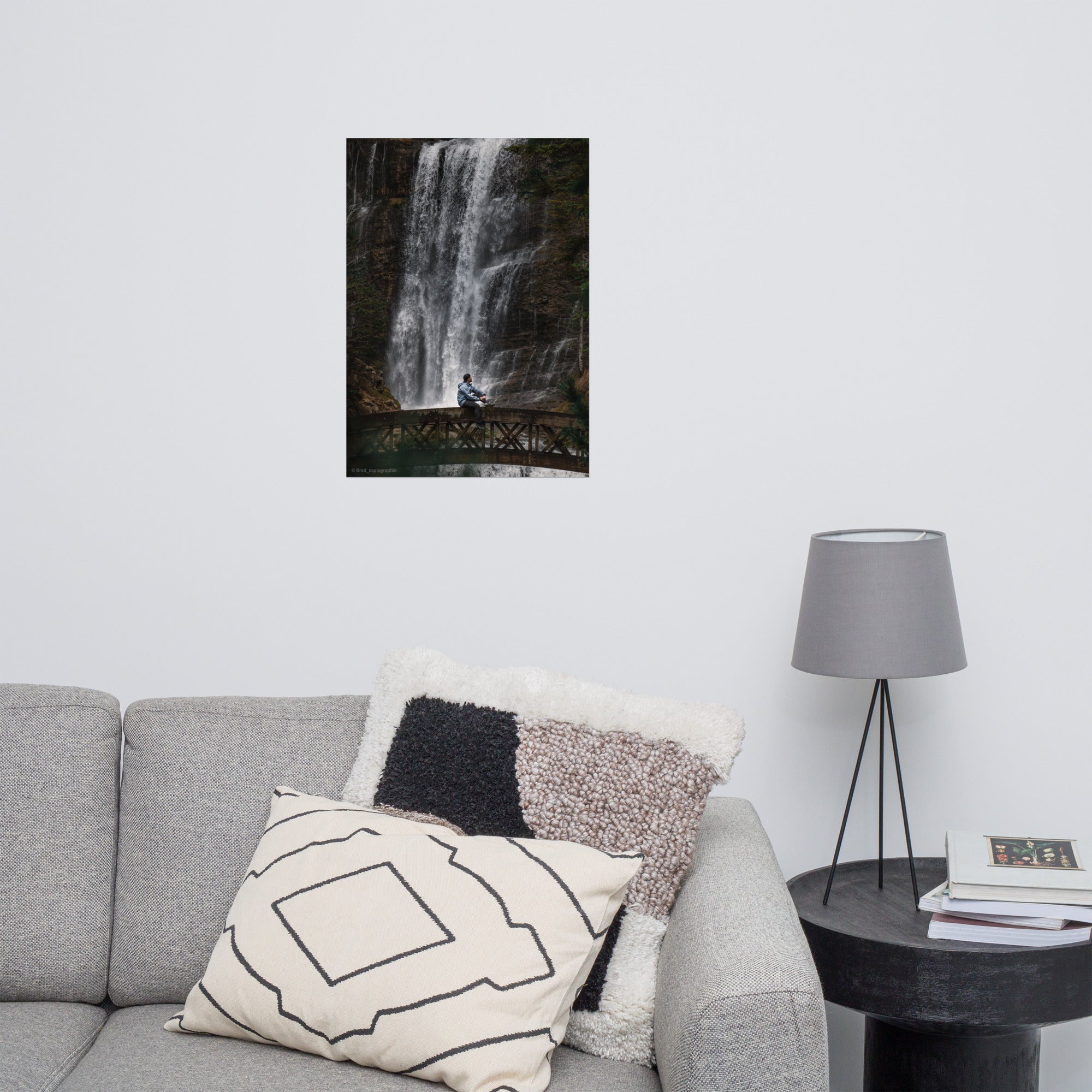 Homme méditatif assis sur une structure en bois au-dessus d'une rivière tumultueuse avec une cascade puissante en arrière-plan – photographie signée par Brad_explographie.