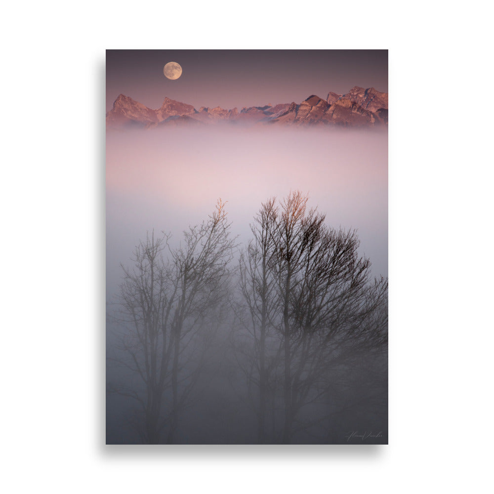 Deux arbres émergeant d'un brouillard mystique avec des montagnes lointaines et une lune radieuse en arrière-plan, une œuvre signée Florian Vaucher.