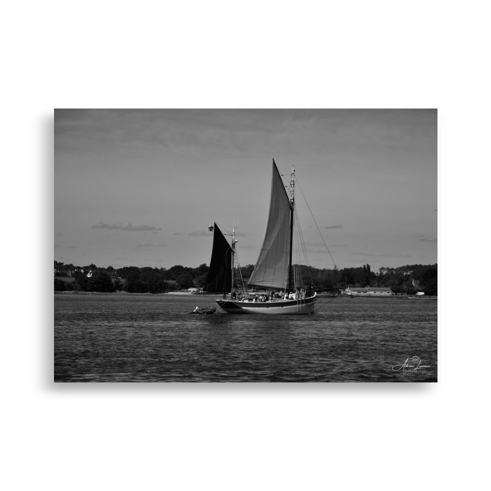 Photographie noir et blanc 'Hissez haut !' par Adrien Louraco, représentant un voilier naviguant sur le Golfe du Morbihan, avec des contrastes saisissants entre mer et ciel.