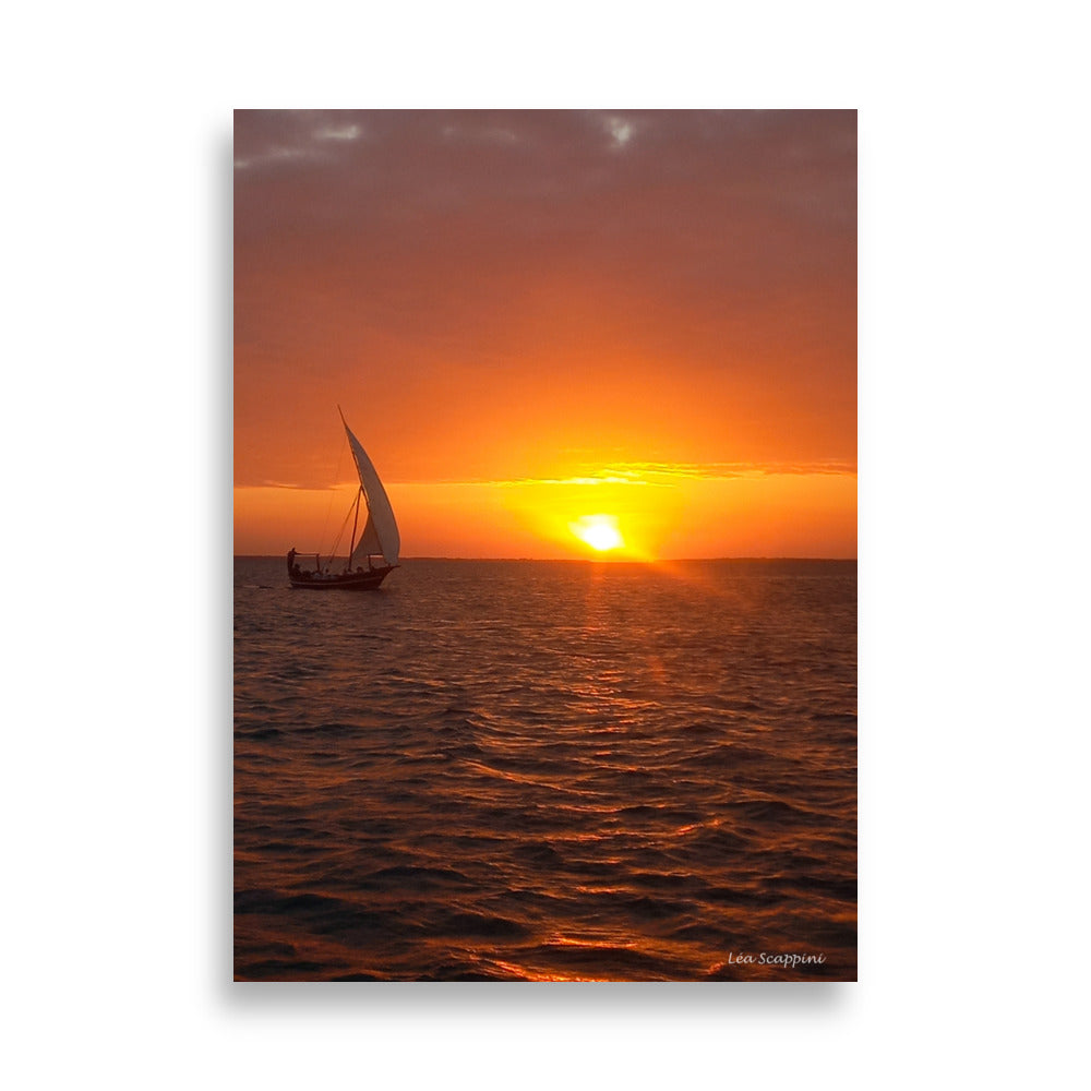 Photographie d'un dhow traditionnel naviguant sur l'océan au coucher du soleil, capturée par Léa Scappini, dépeignant une scène de tranquillité et de solitude apaisante.