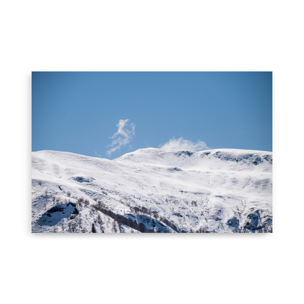 Photographie des montagnes enneigées du Cantal avec un nuage en forme de petit monstre.